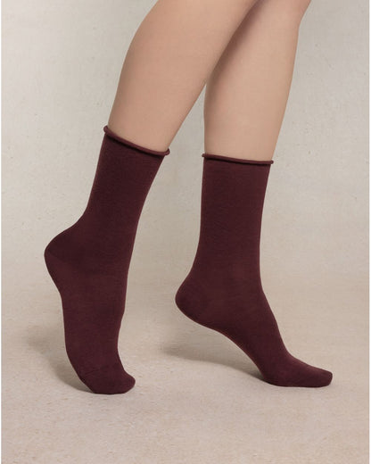 Burgundy socks worn by a person on a beige background