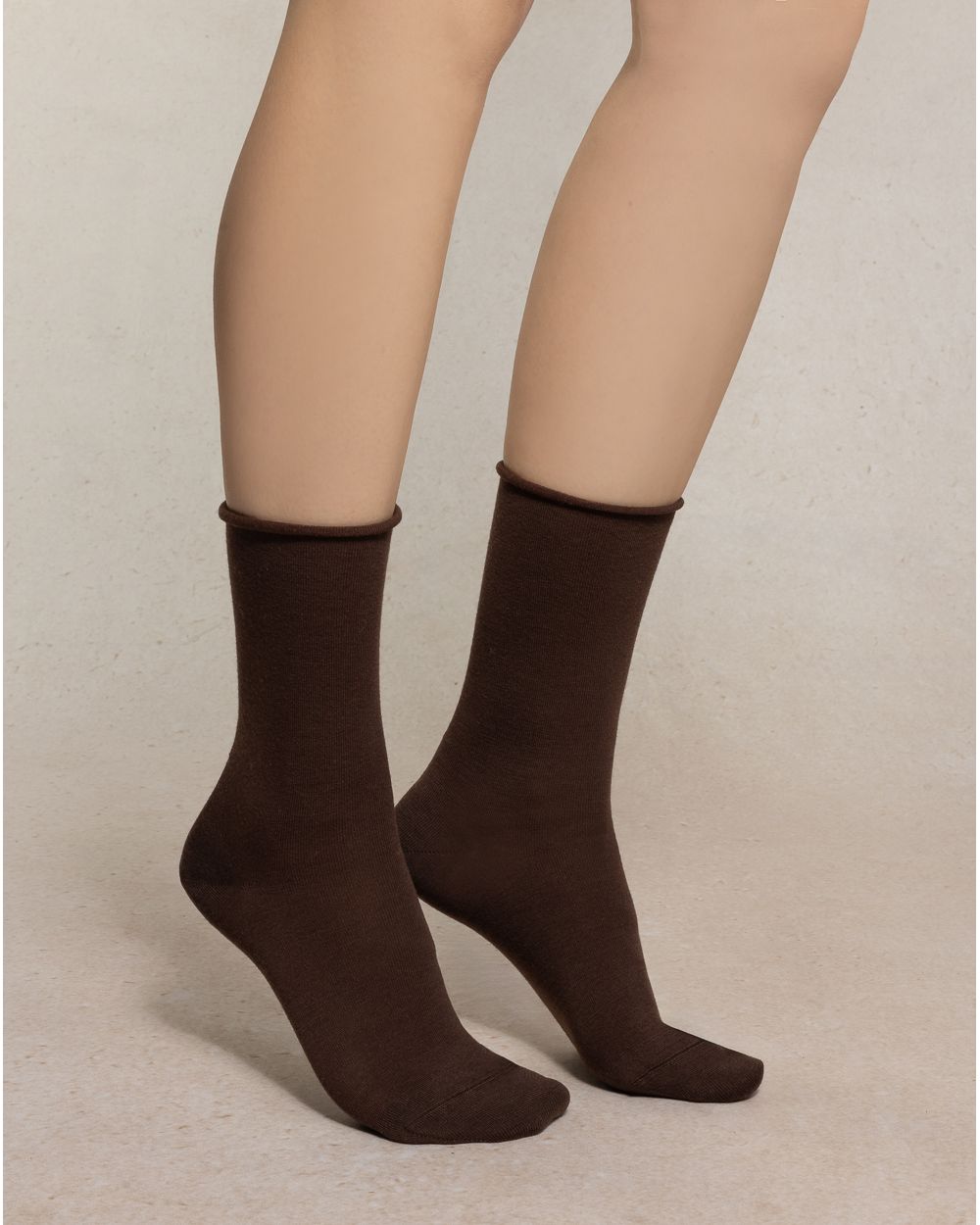 Brown socks worn by a person on a plain background